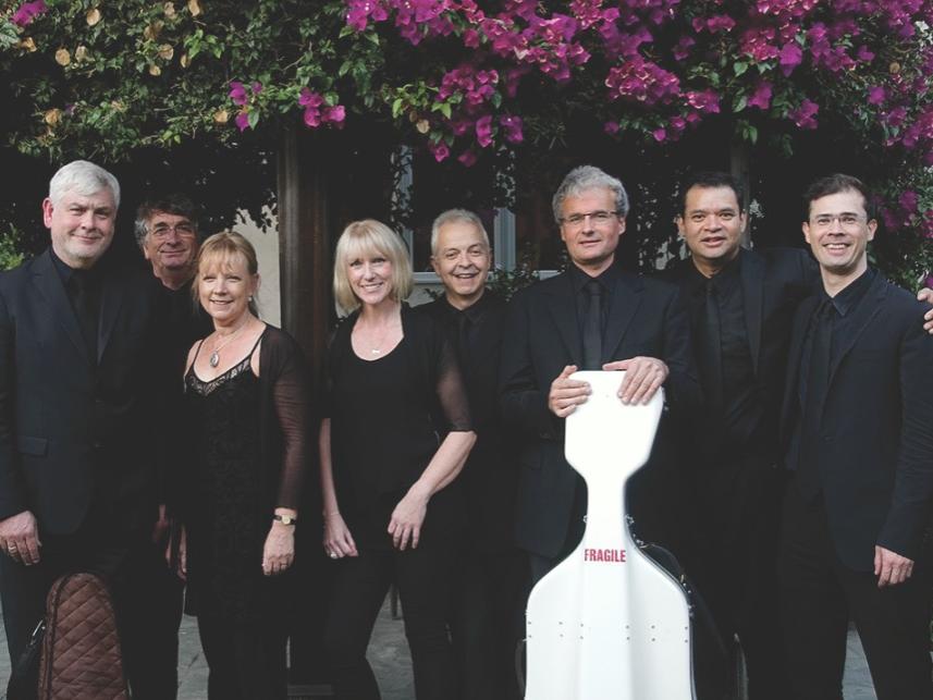 A group of people stand in a line and look at the photographer.