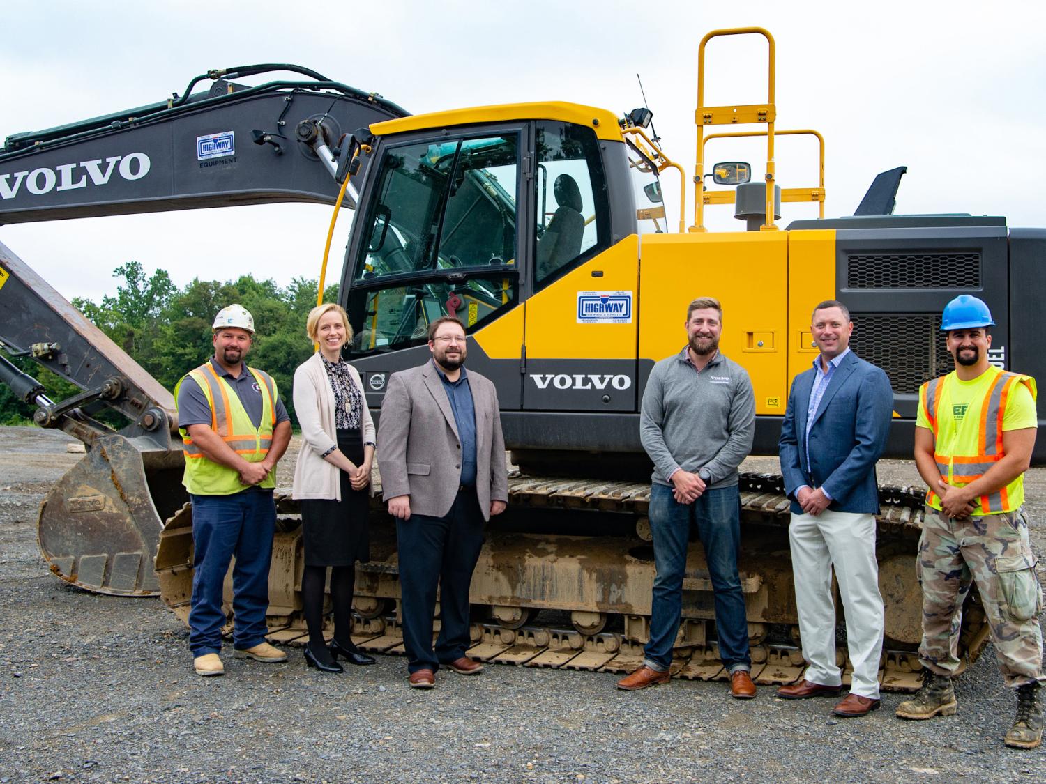 People gather around a Volvo EC220 excavator on loan for Pennsylvania College of Technology students’ use.