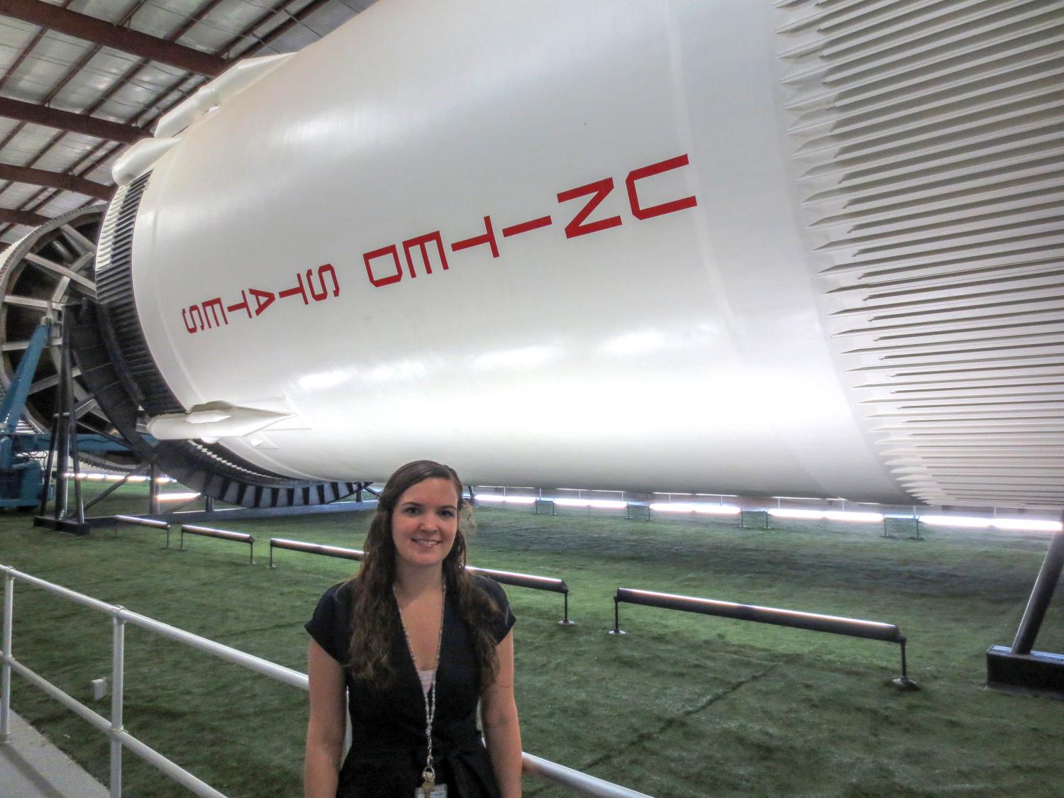 Sarah Huppman standing by a rocket at the space center