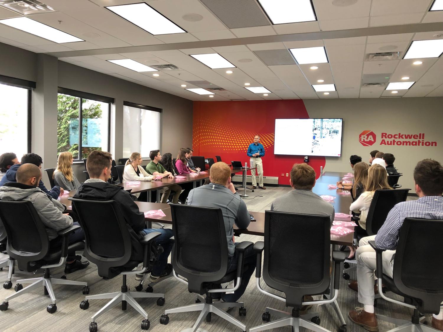 People sitting around a table listening to a presenter talk