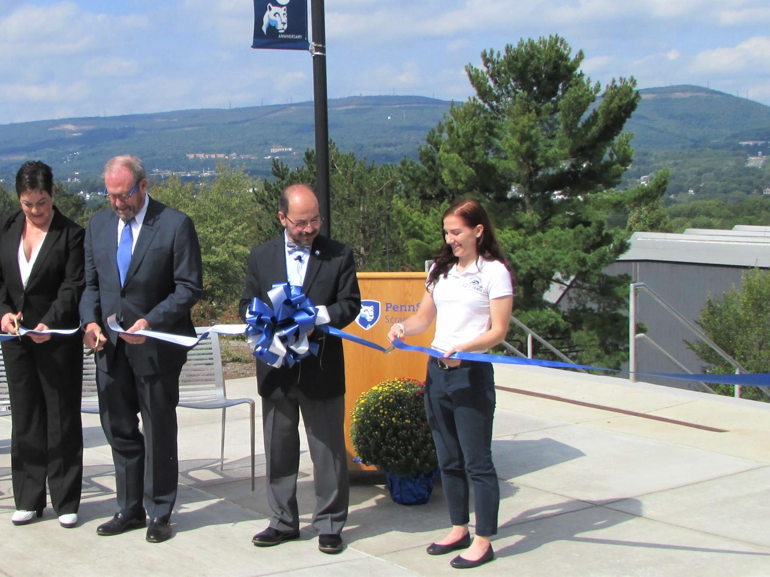 Several people cut a ribbon to dedicate the new Penn State Scranton patio