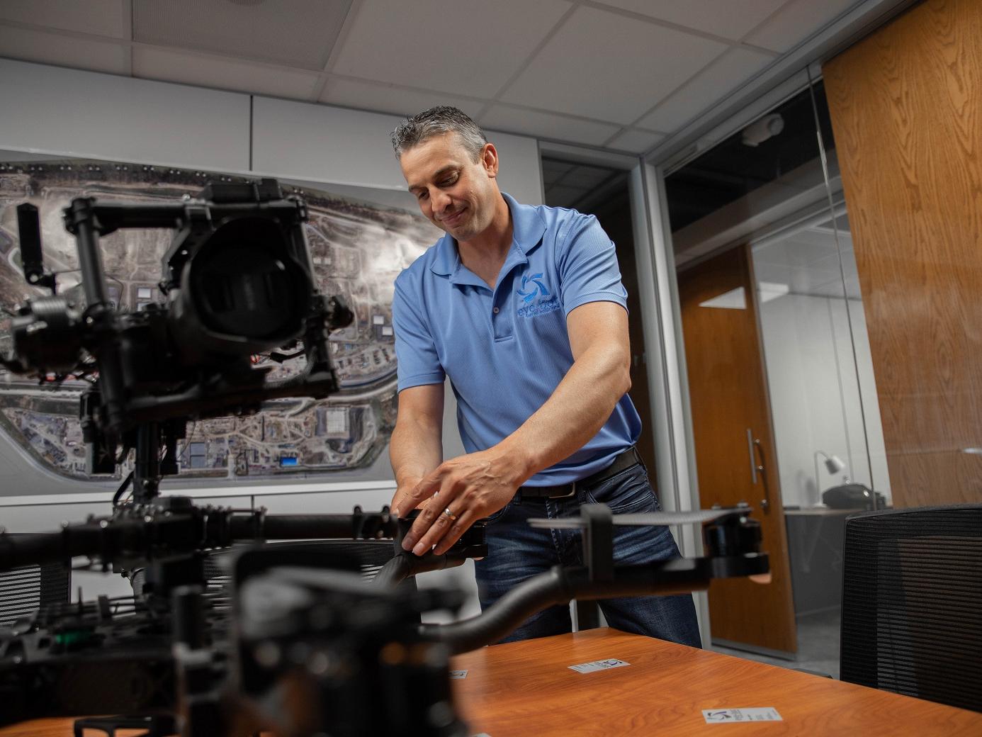 Man touching drone on table