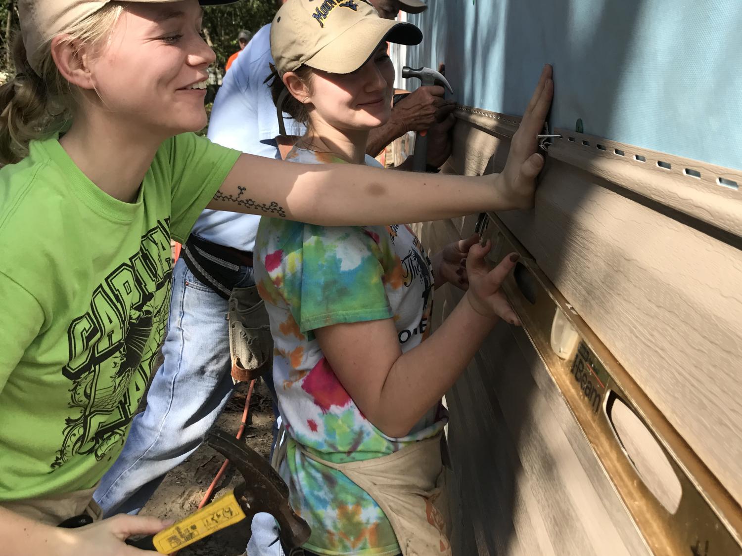 Students install vinyl siding during a Habitat for Humanity build in Florida.