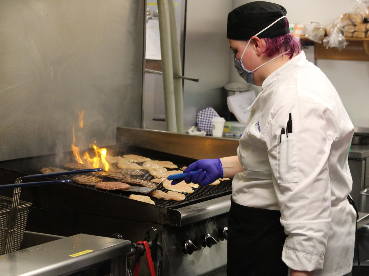 Sarah Graham, food preparer, grills up delicious chicken and burgers at the new Market North in Warnock Commons [nid: 648042]