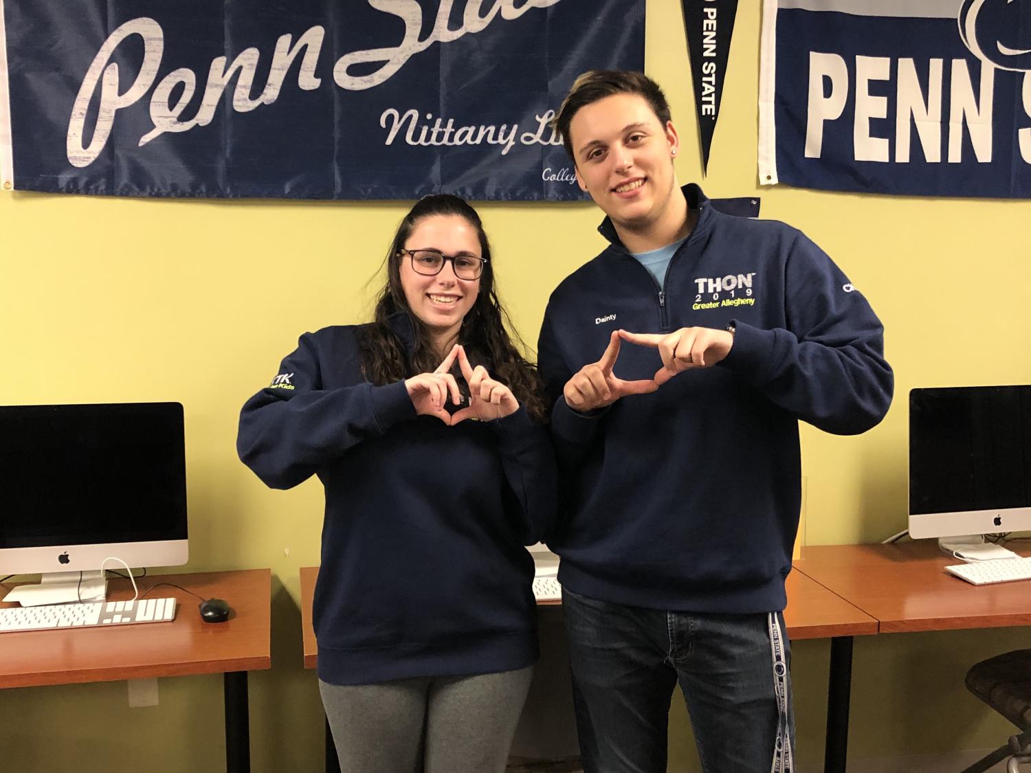 Students standing in front of Penn State Flag