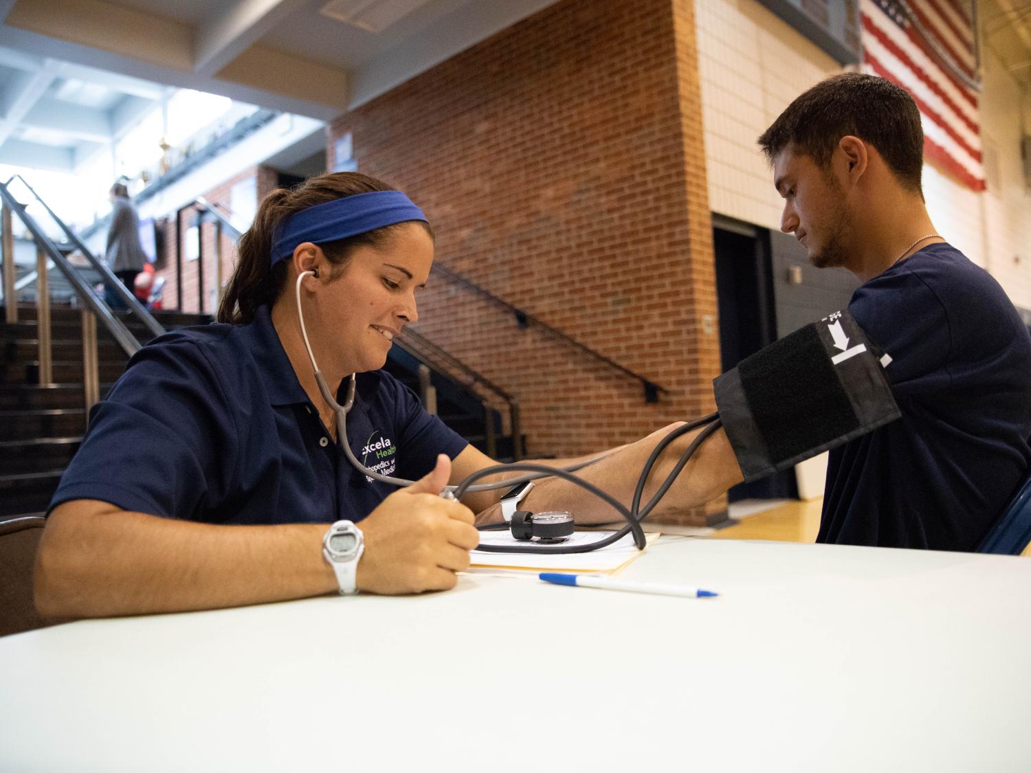 Athletic trainer takes blood pressure of student-athlete