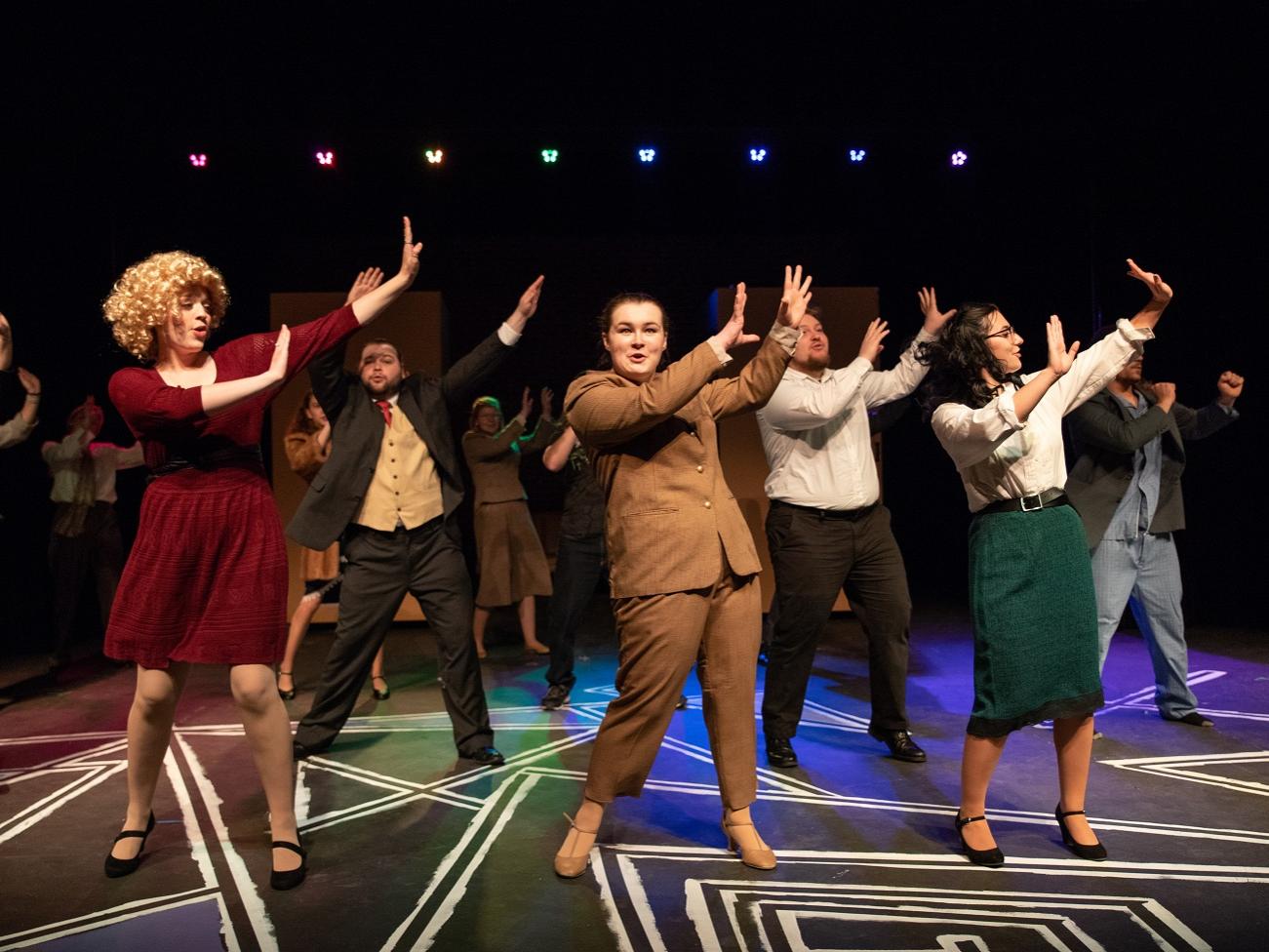 Musical cast members singing and dancing