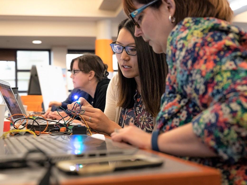 Two women work with Hummingbird Duo robotics kit