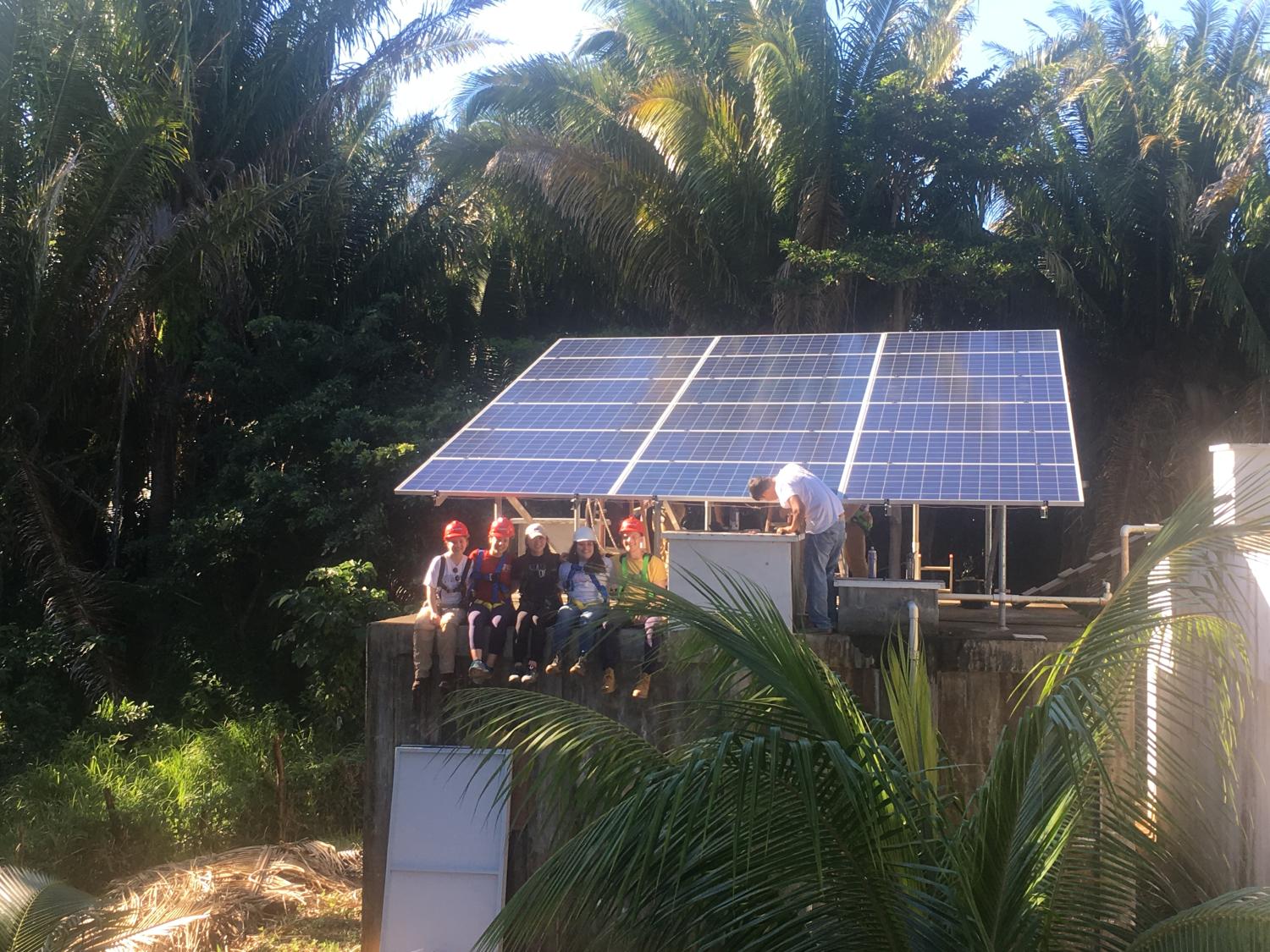 Sixx students pose by a solar panel they recently installed in Roatan, Honduras