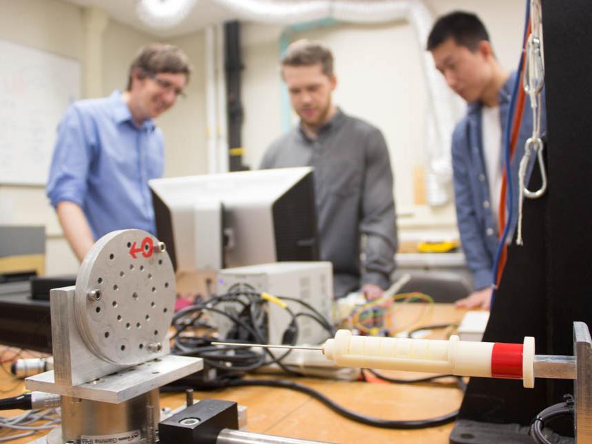 Jason Moore, associate professor of mechanical engineering, David Pepley, a doctoral student studying mechanical engineering, and Yichun (Leo) Tang, undergraduate student studying mechanical engineering work with the needle simulator training device.