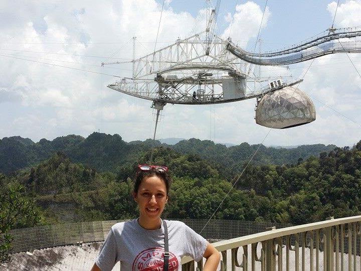 Penn State graduate student Kelly Nunez Ocasio stands in front of the Arecibo Observatory in her native Puerto Rico 