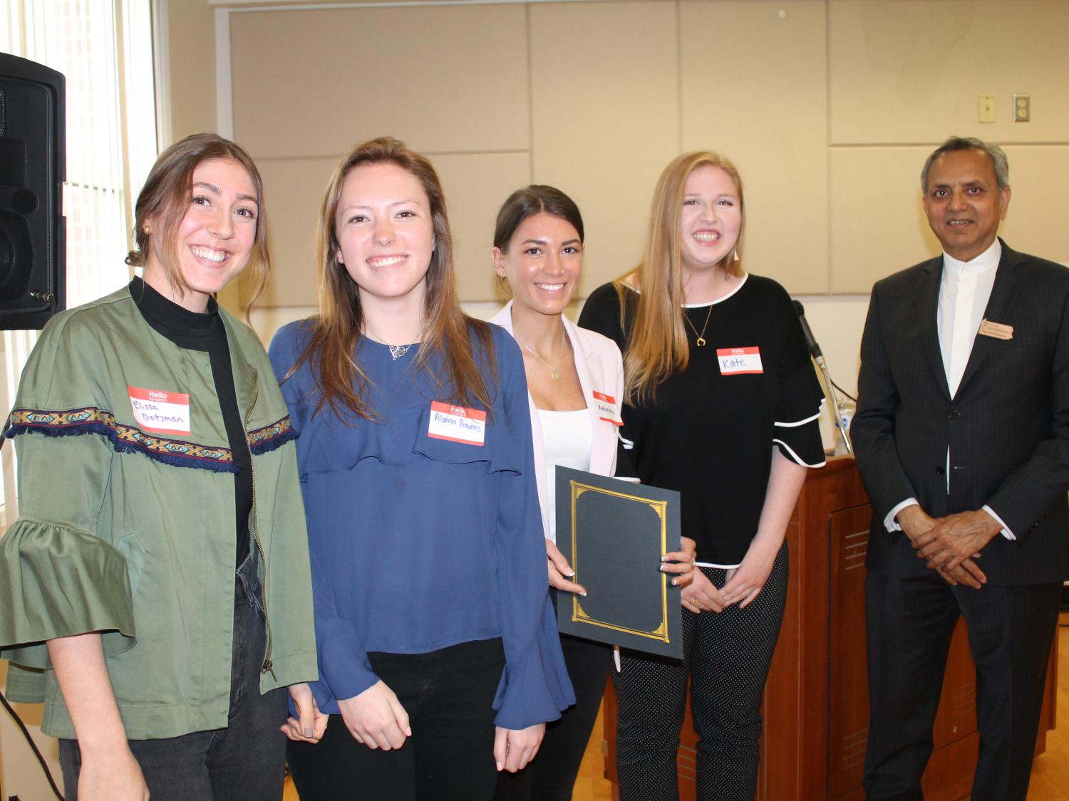Chief Sustainability Officer Paul Shrivastava congratulates students from Tara Wyckoff's communications class on their winning project