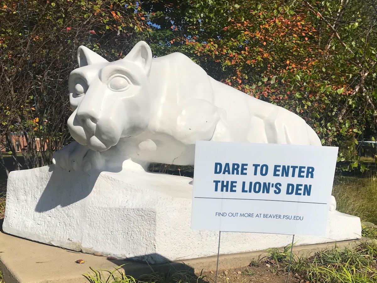 Dare to enter the Lion's Den sign sits in front of lion shrine.