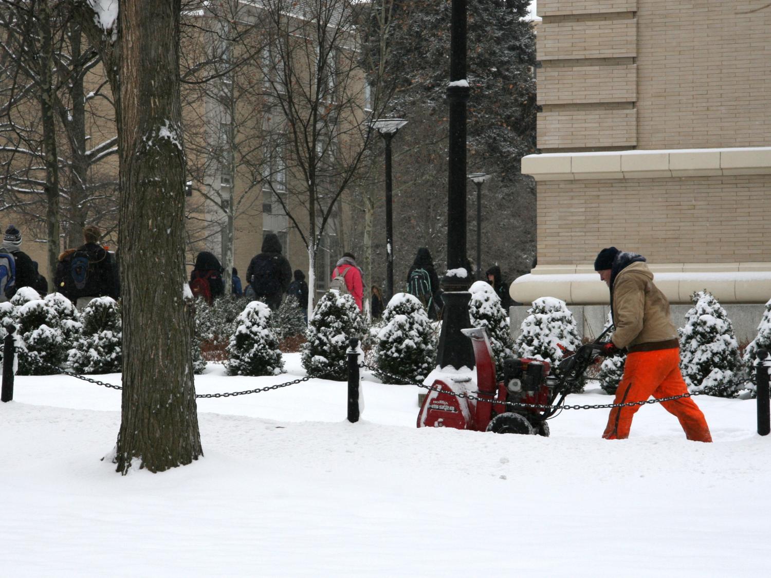 OPP staff member uses a snowblower to clear sidewalks near Willard Building.