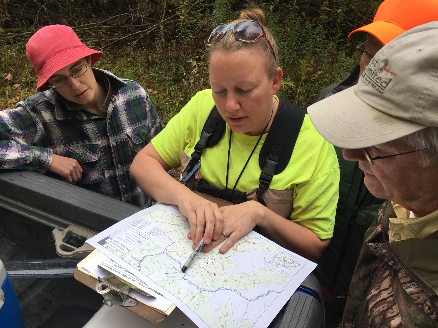 Volunteers collecting water samples look at a map to find their next location 