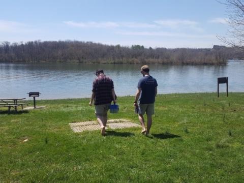 Two people facing out looking at a lake