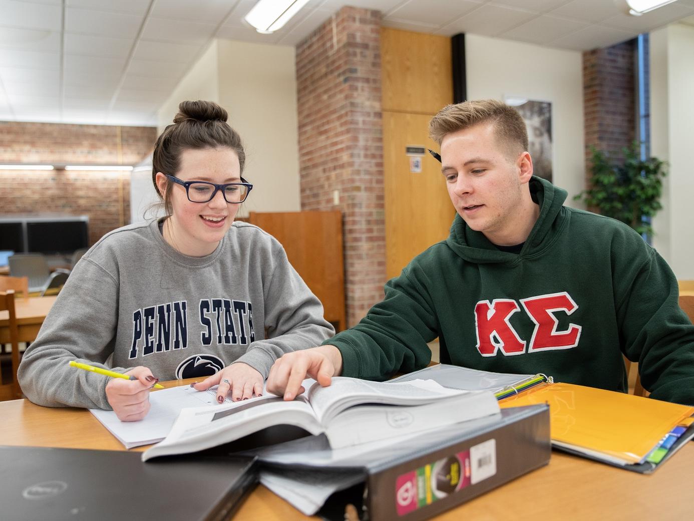 Julia Westerman and Brandon Fello sit in library