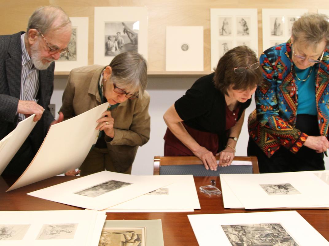 Jim Goodfriend looking at prints with faculty and museum director, Jan Muhlert