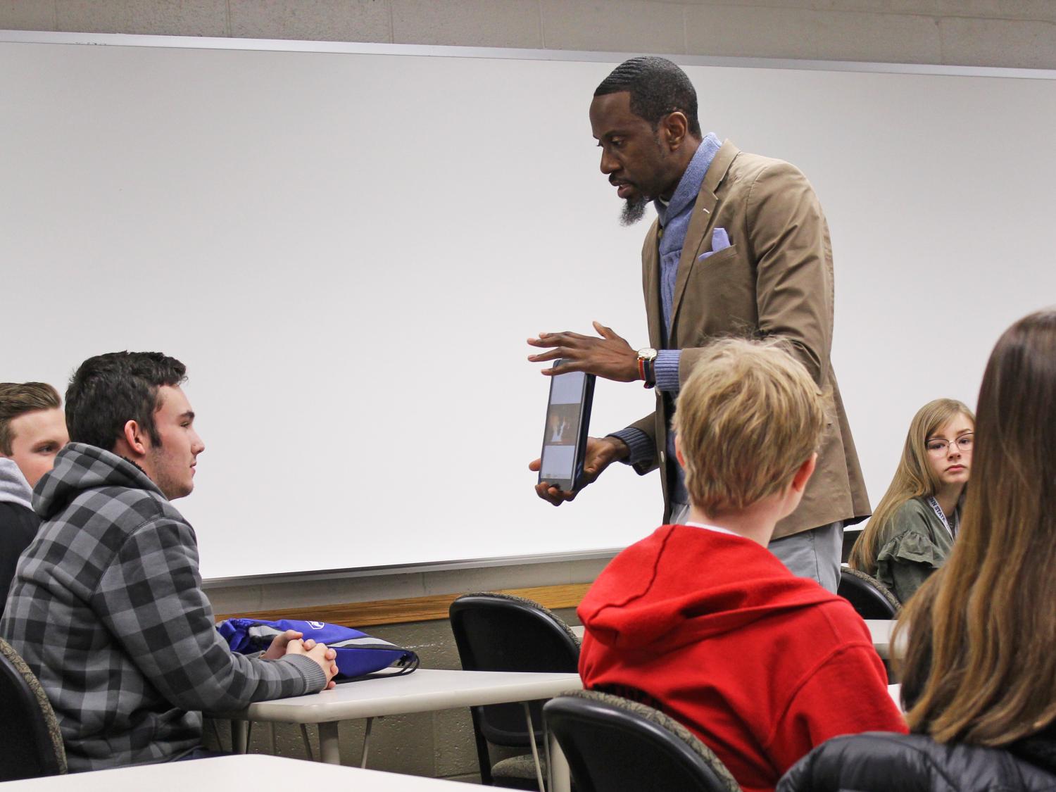 Students looking at a tablet in professors hands