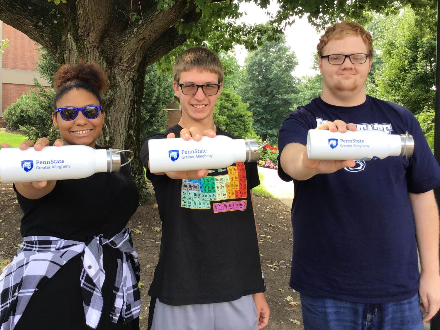 Three students holding white water bottles displaying Greater Allegheny Logos