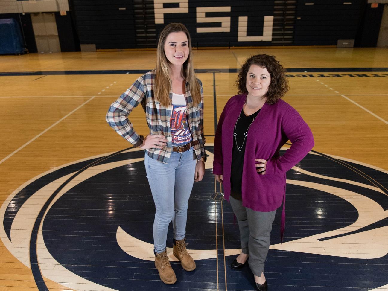Two women standing in middle of gymnasium floor