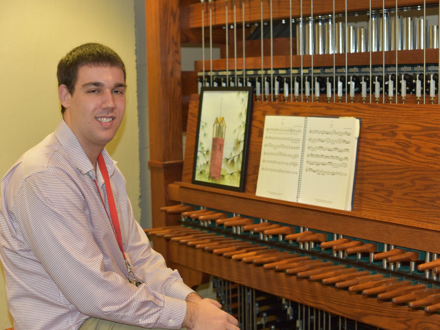 James Lisi is pictured, smiling in front of Penn State Behrend's practice carillon.