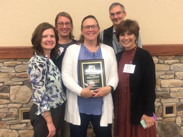 Three women and one man pose with Dr. Jen Jewell who received a PPTA award