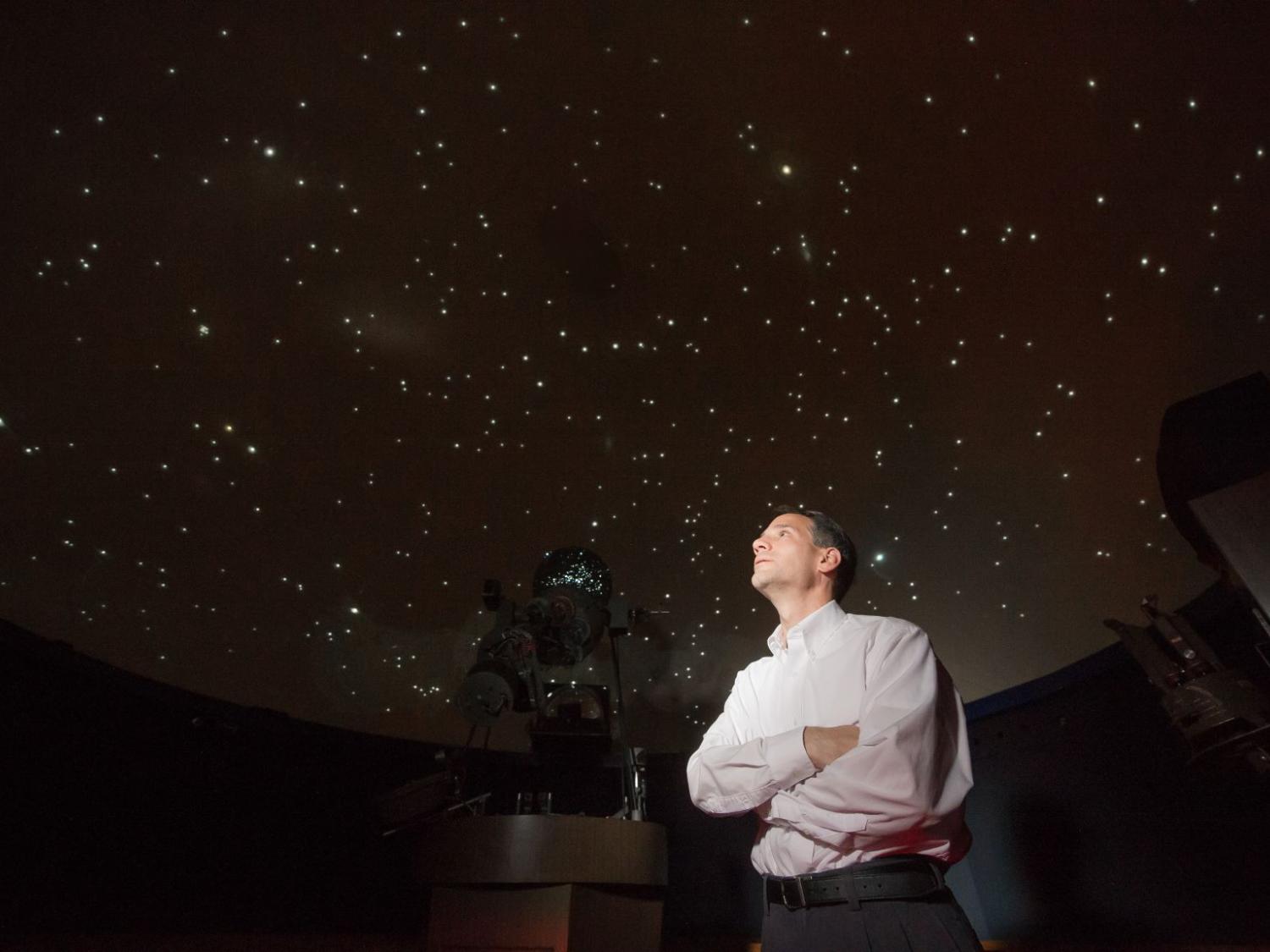 Jim Gavio, director of Yahn Planetarium, looks up at the starfield on the planetarium's ceiling.