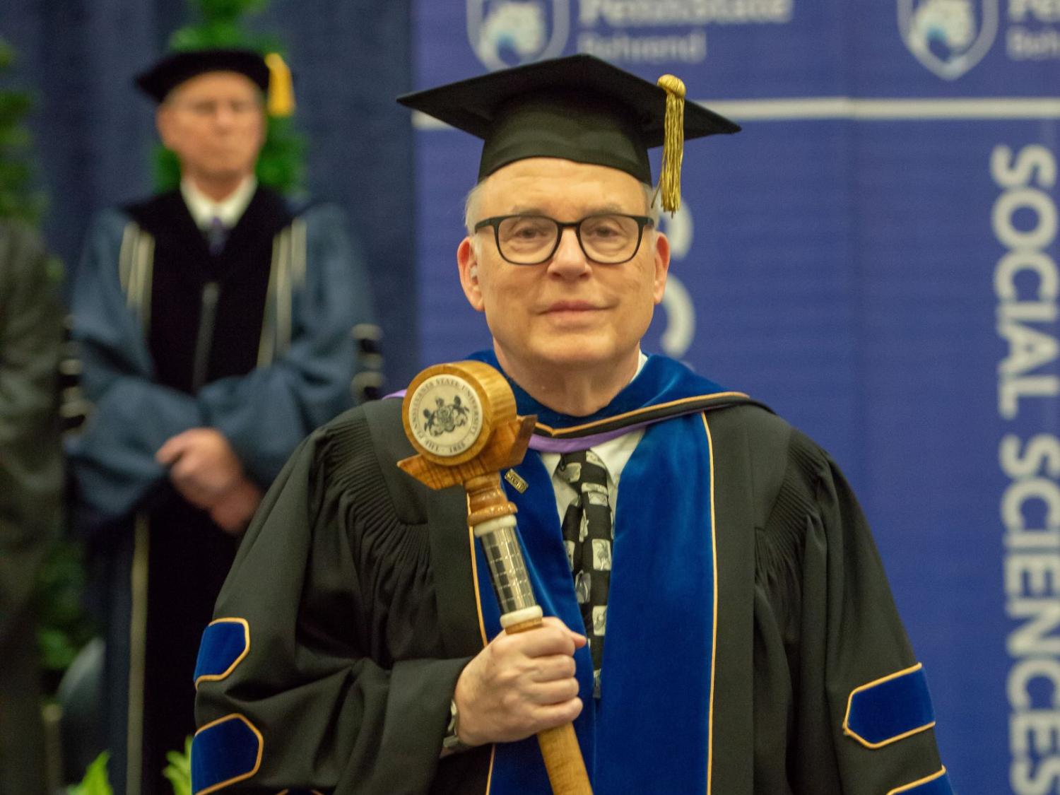 John Gamble carries the Penn State Behrend mace during a college commencement program.
