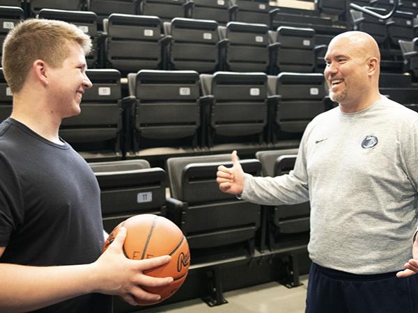 Joshua Crayton (left) and Lou Zadecky, athletic director (right) catch up off the court.