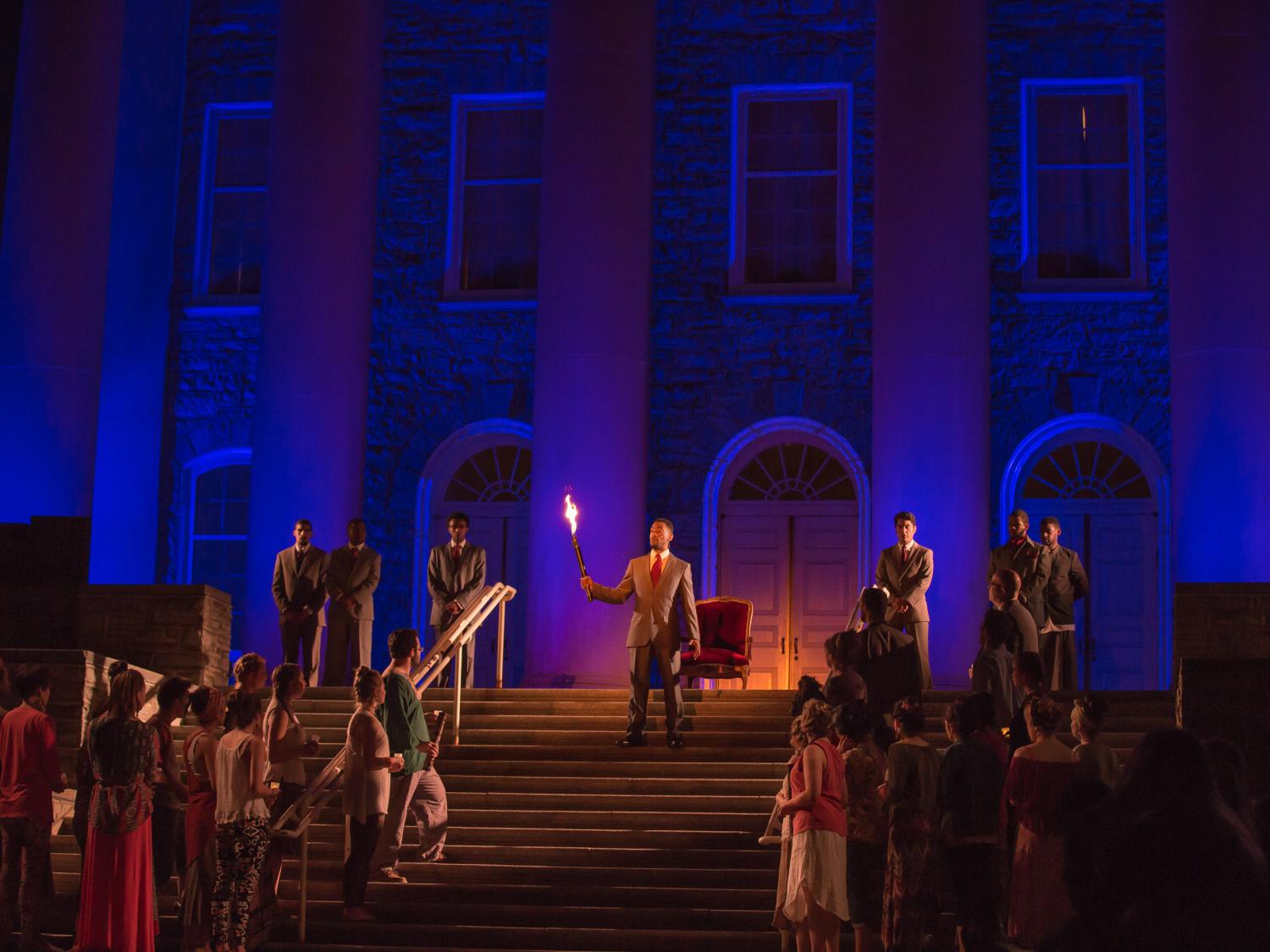 Penn State Theatre actors perform on the steps of the Old Main building.