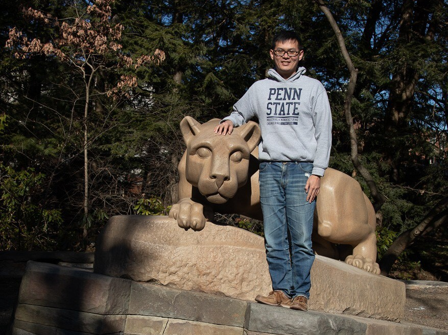 Man stands at Nittany Lion Shrine and smiles.