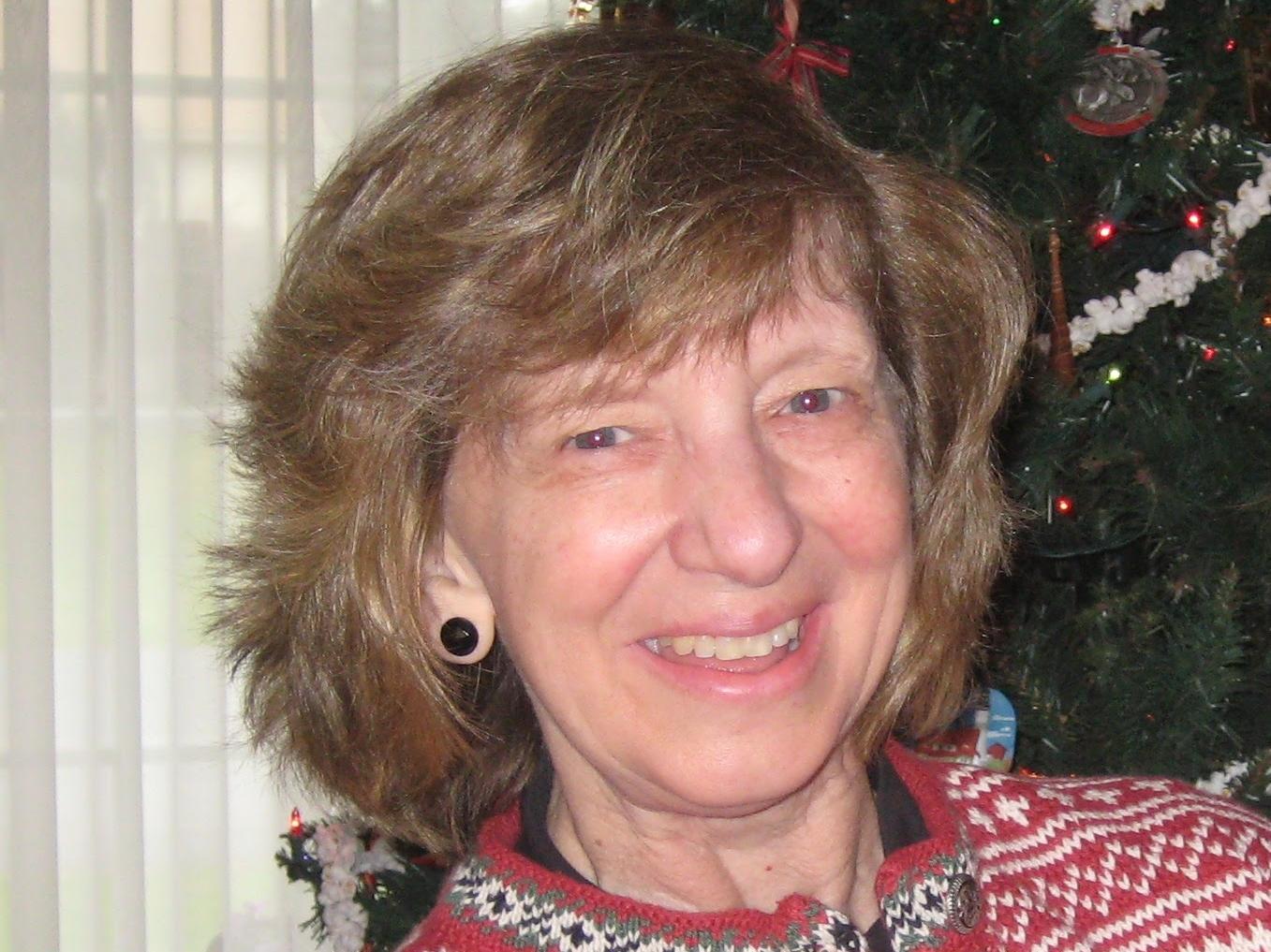 Photo of Kathy Gray in front of Christmas tree