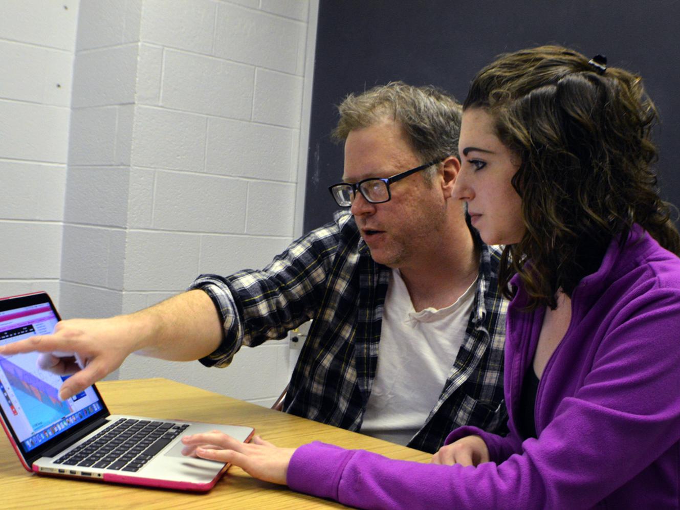 students looking at financial data on laptop screen