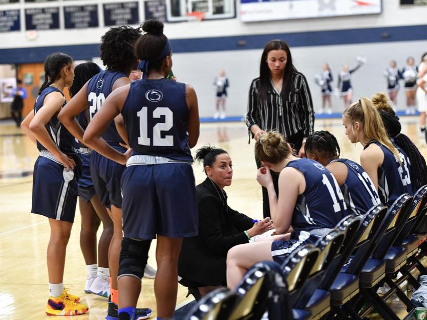 A group of women's basketball players in a huddle.
