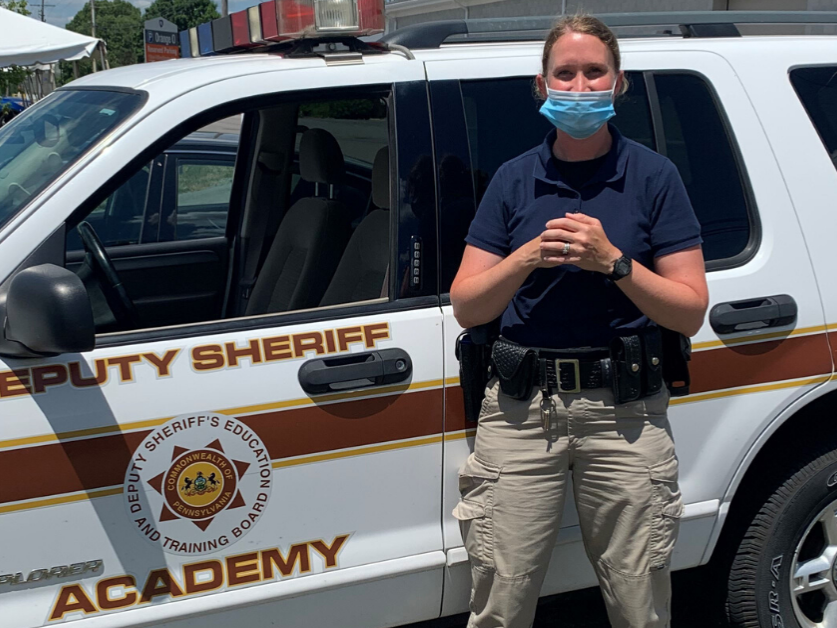 Sheriff deputy standing in front of training vehicle