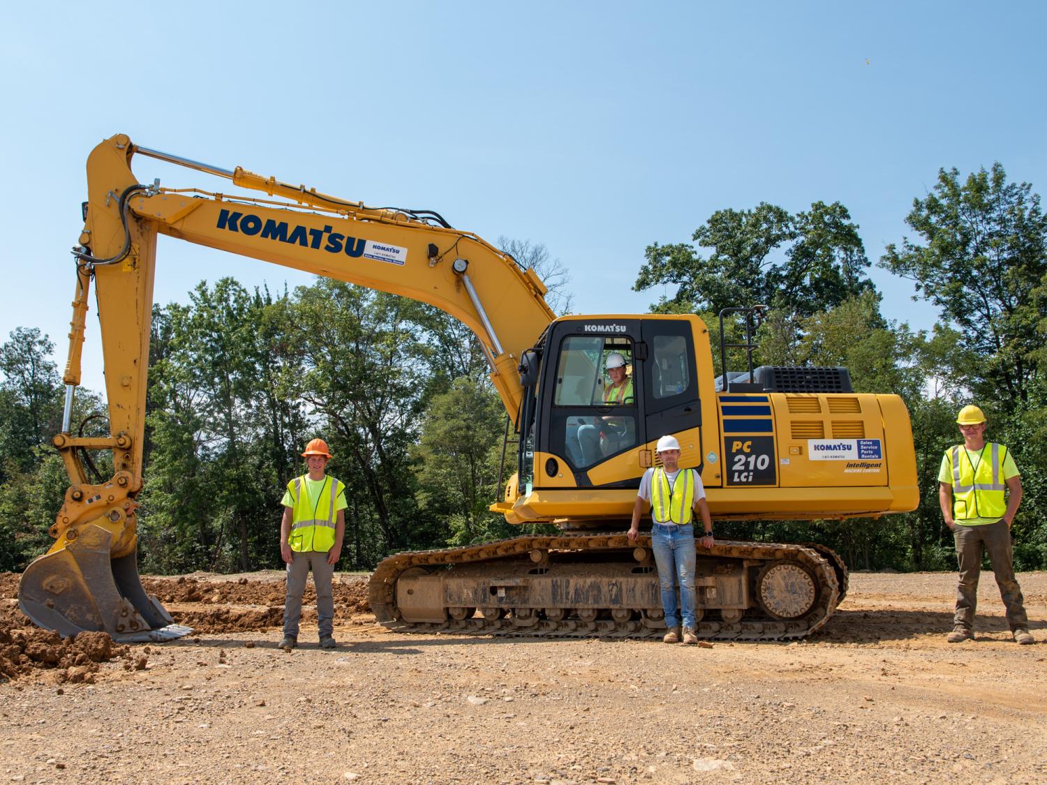 A piece of heavy excavating machinery with several people standing by it