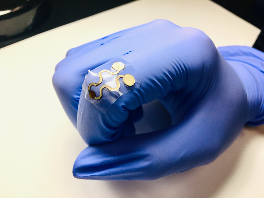 gloved hand wearing a flexible sensor over knuckle