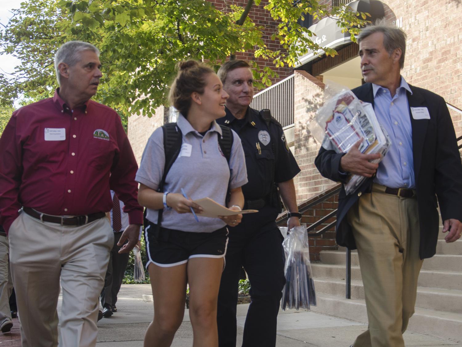 Officials and a student walking in downtown