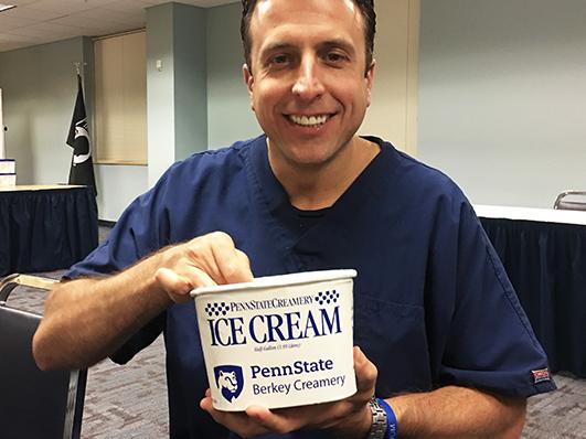 Larry Trubilla holding a tub of Penn State ice cream.