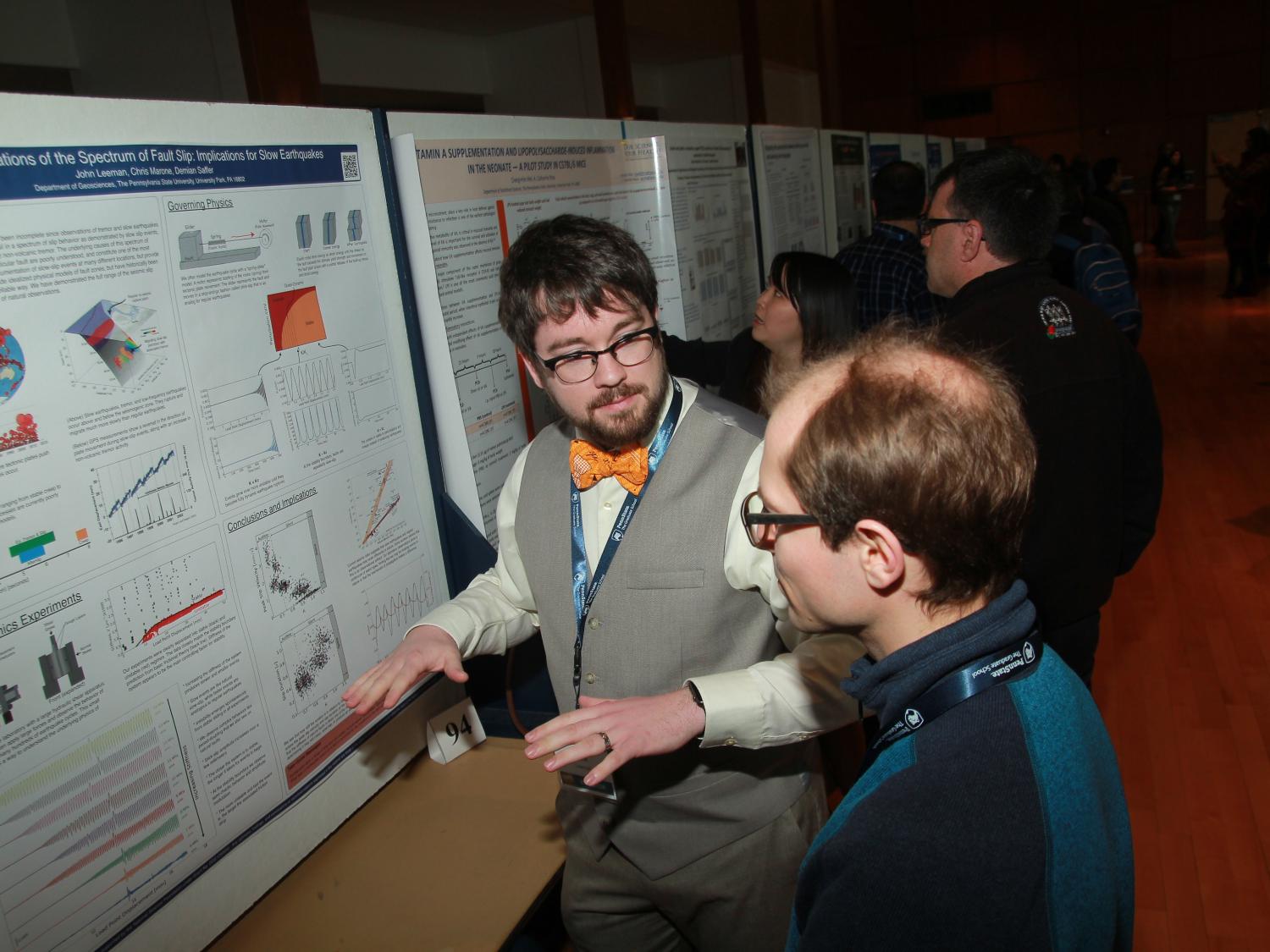 student explaining research poster