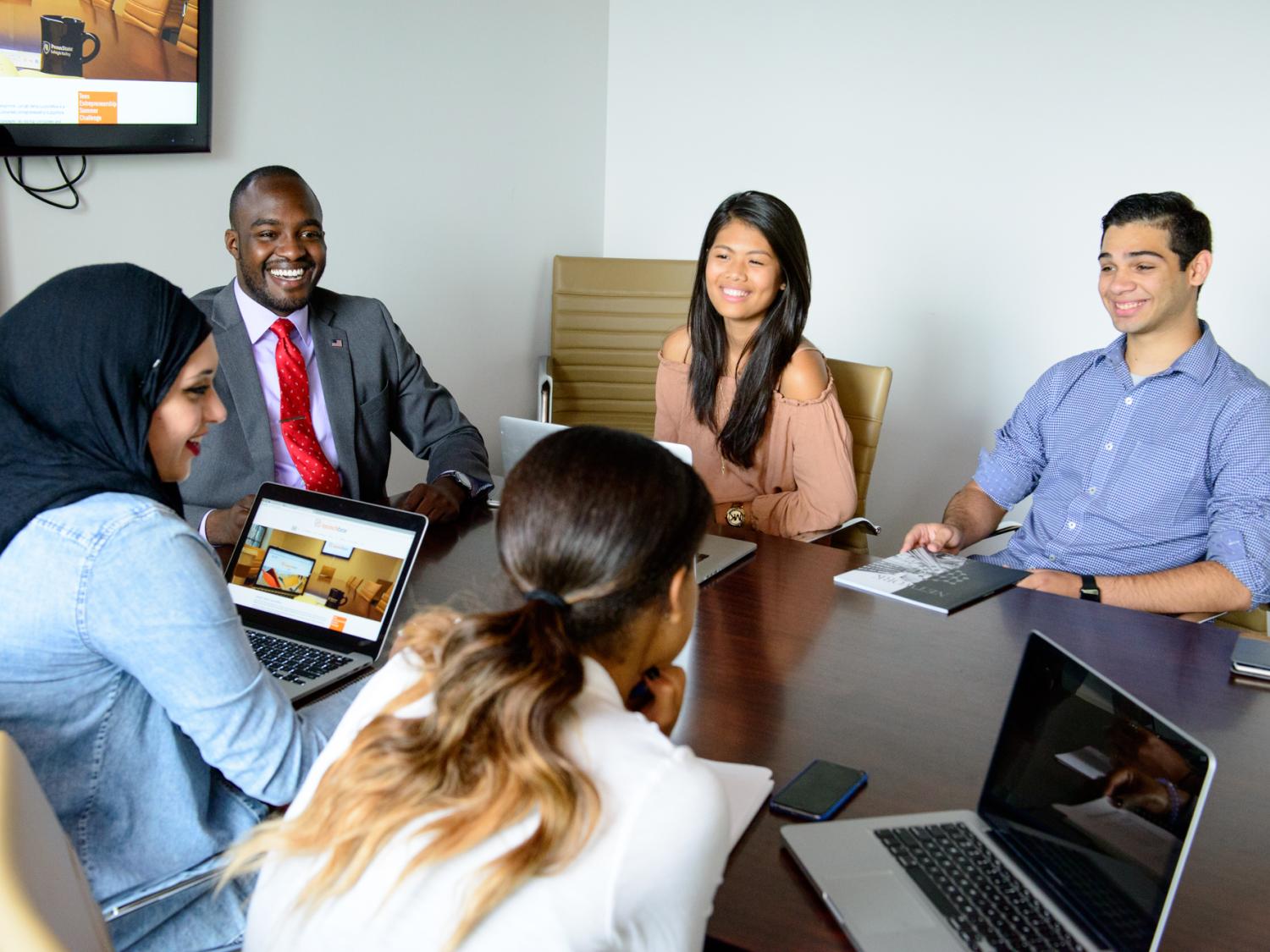 Group of students with laptops working at a desk