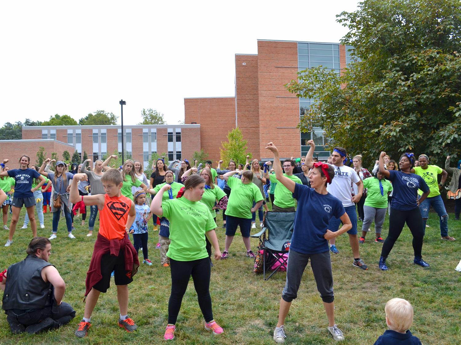 Members of For Good Troupe dance on a grassy lawn. 