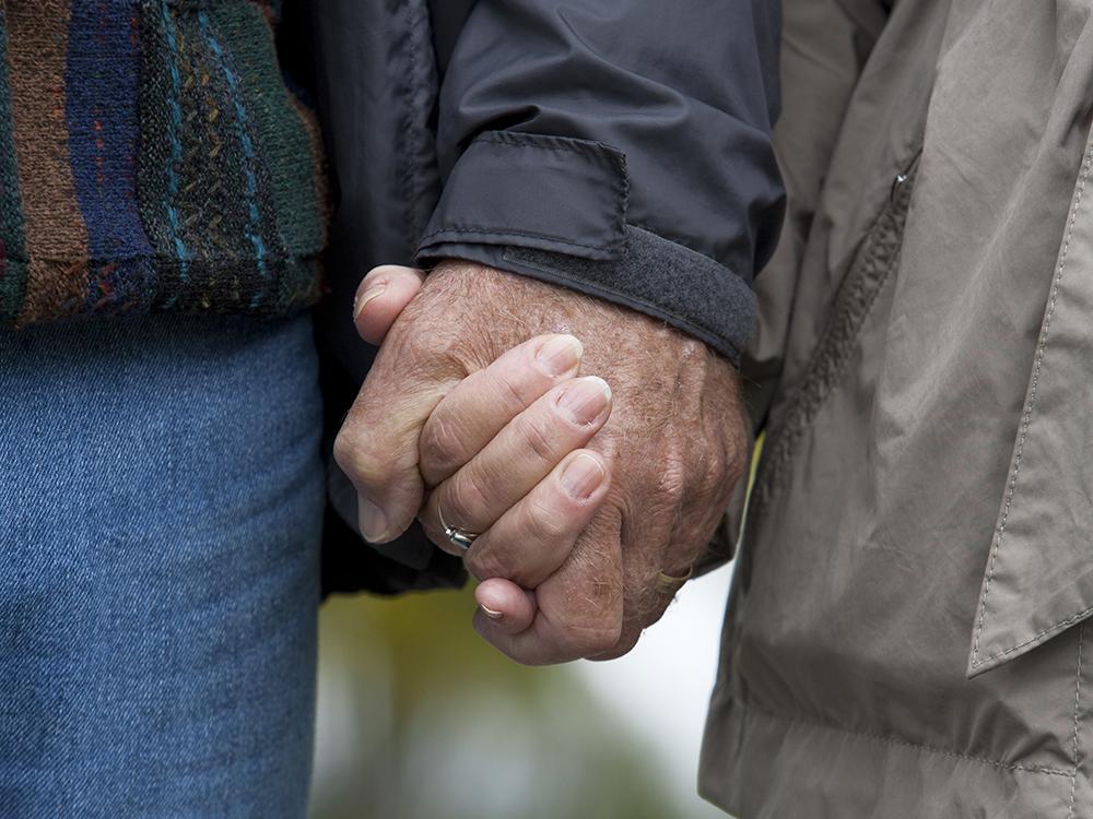 A close-up of two people holding hands