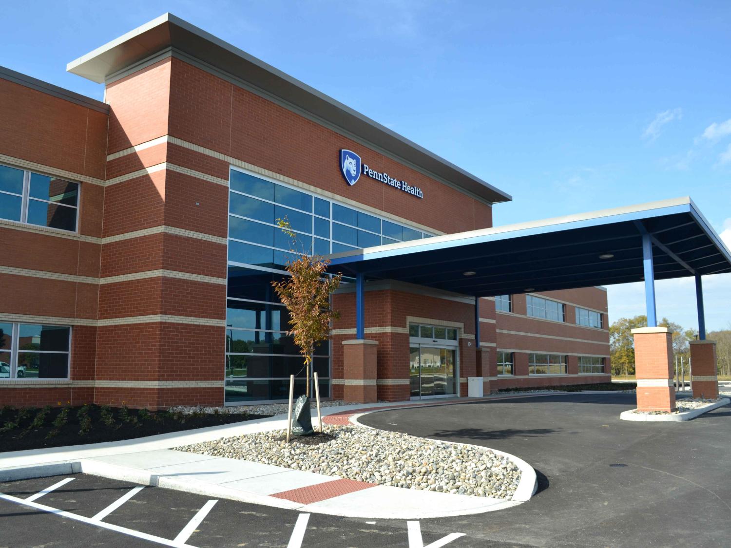 An exterior photo of Penn State Health Medical Group -- Lime Spring Outpatient Center, a brick building with dark windows and an overhang at the front entrance.