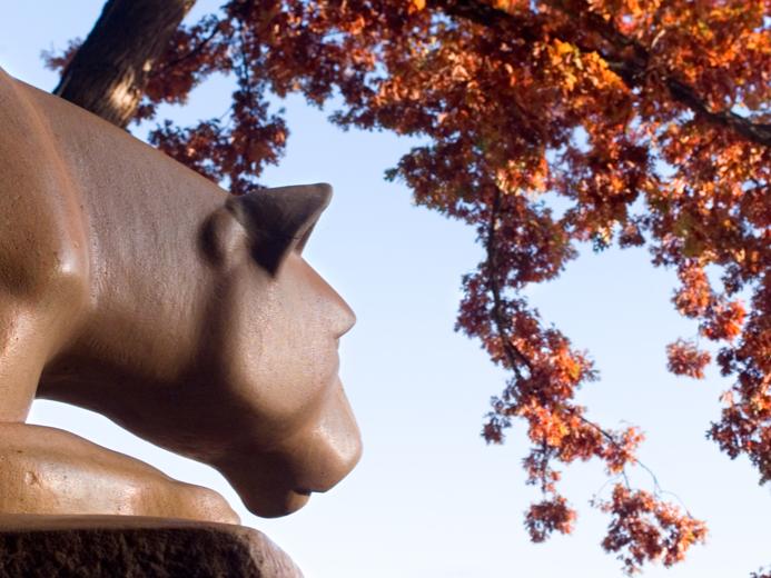 Nittany Lion Shrine with red fall leaves overhead.