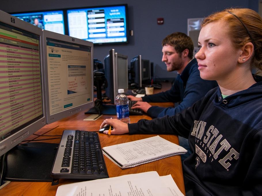 Two students work on computers in the financial trading lab at Penn State Behrend.