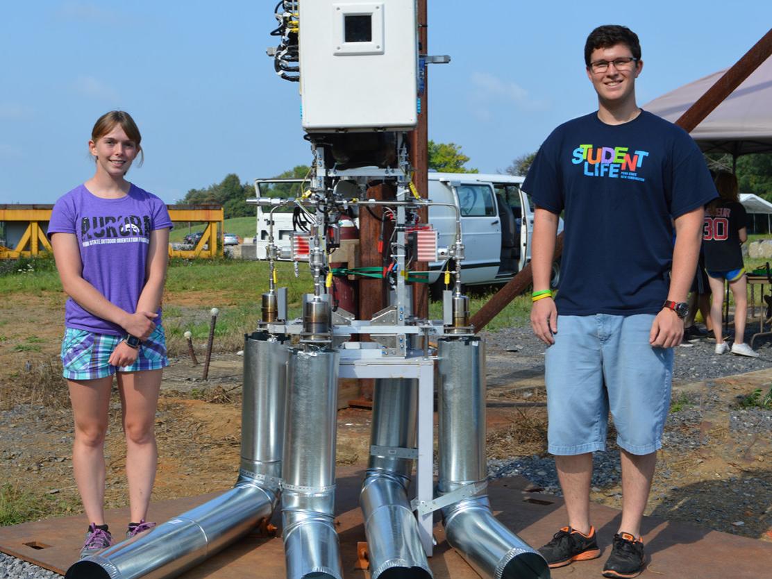 Mitch Hastings and Cassie Hannigan stand next to Lunar Lion test equipment