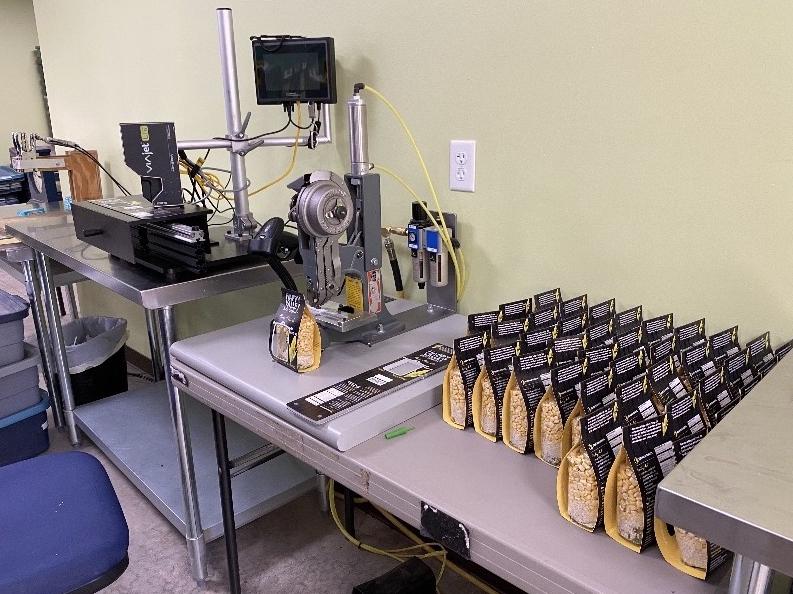 A machine prints labels on bags of soup ingredients.