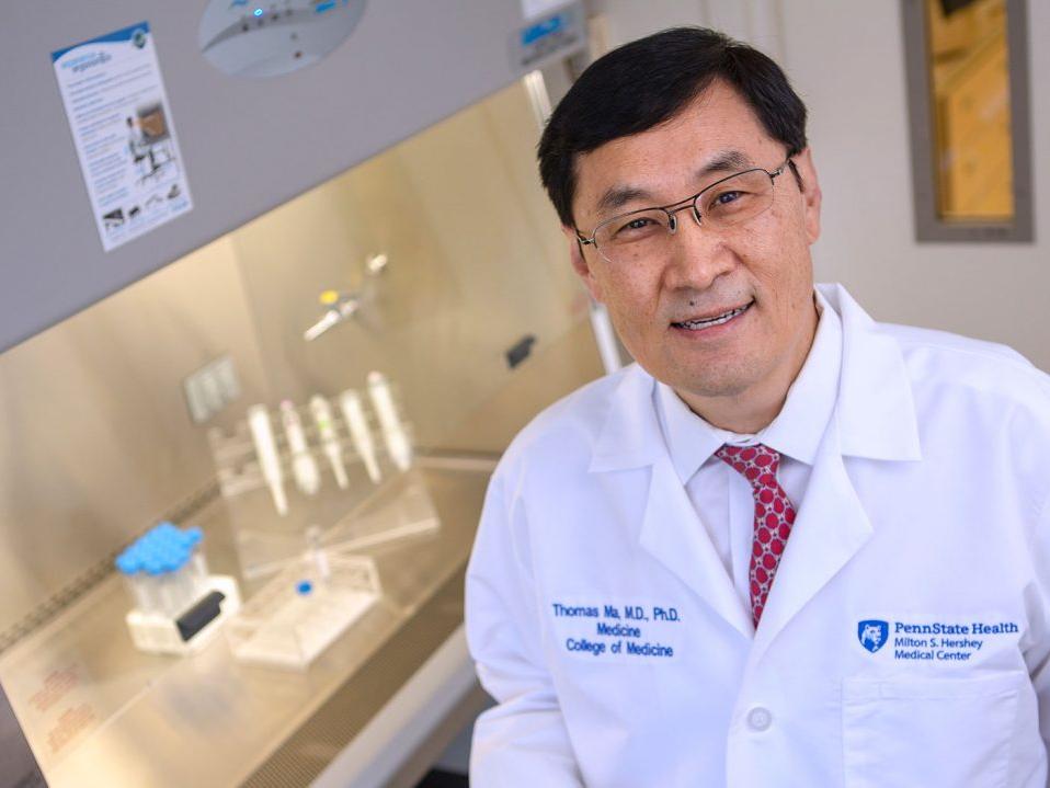Dr. Thomas Ma sits at a laboratory hood at Penn State College of Medicine. 